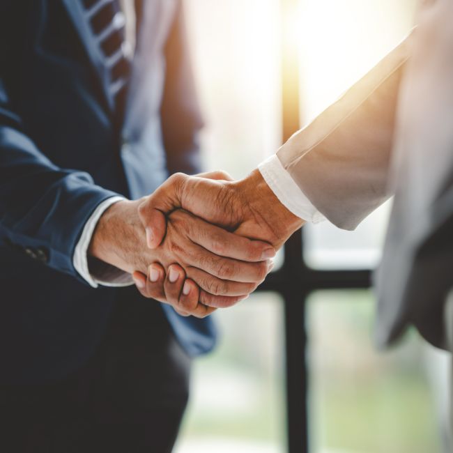 Closeup on two people in business attire shaking hands