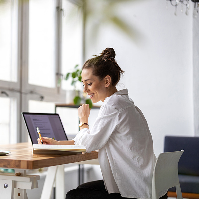An associate works on her laptop taking notes