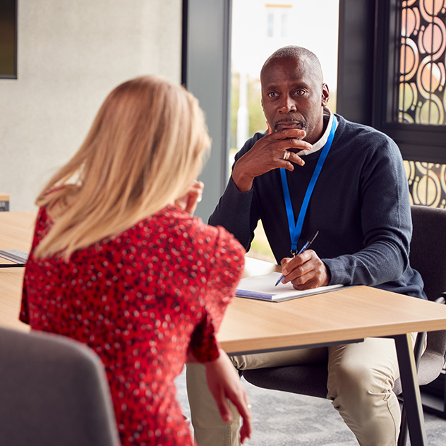 A provider meets with a client, taking notes