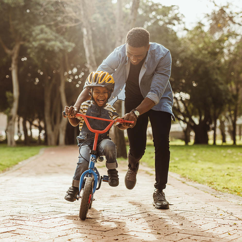 Father teaching his son how to ride a bike